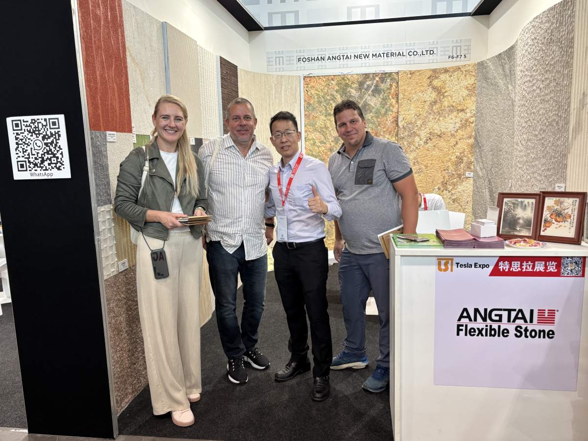 Group of four at Angtai booth, smiling and interacting with flexible stone displays at Marmomac 2025 trade show.